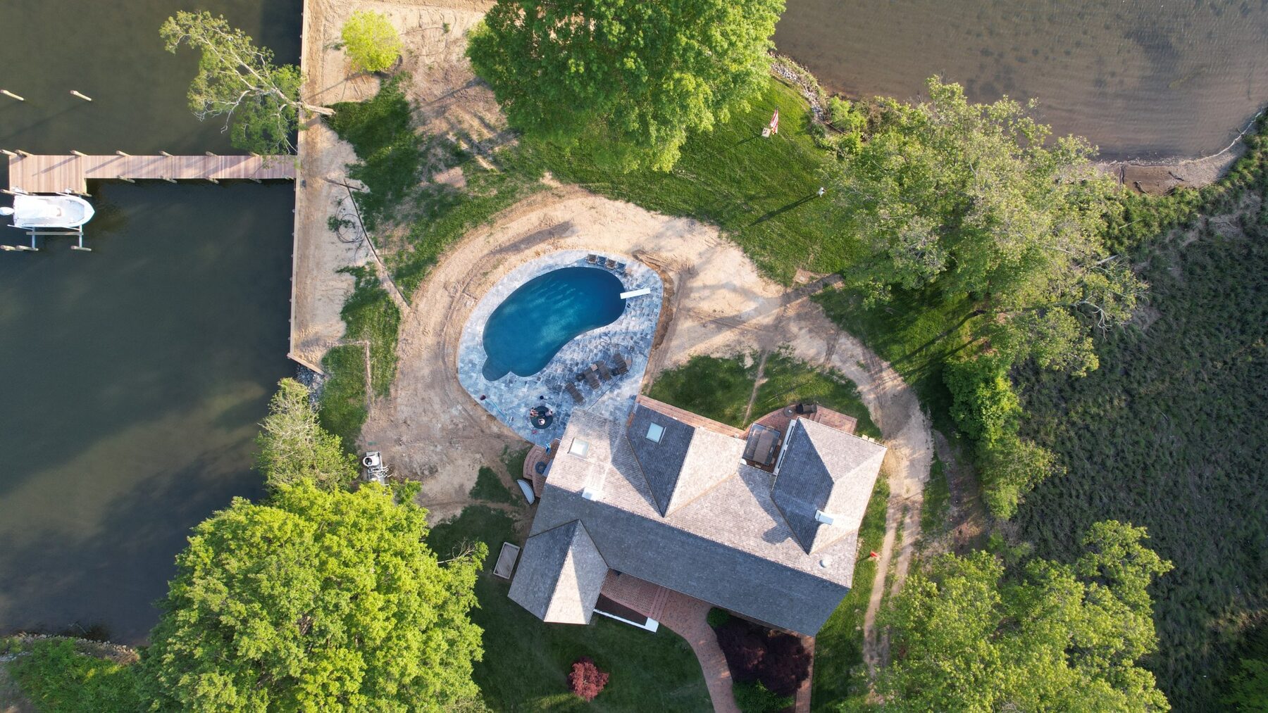 Aerial view of the waterfront property, pool, and dock